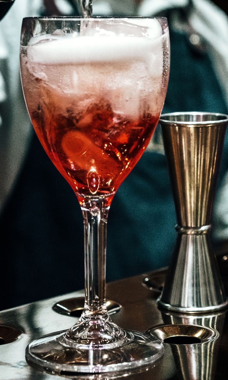 Spritz turnat într-un pahar cu gheață, la bar